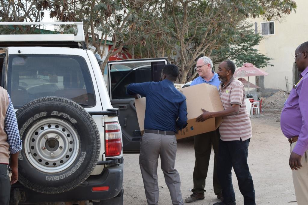 People loading a package into a car