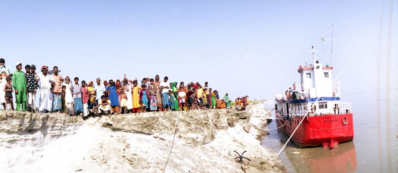 People waiting for boat by riverside